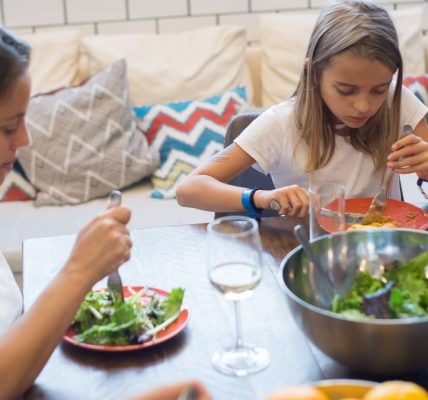 A family enjoying a healthy meal together indoors, emphasizing togetherness and healthy eating.