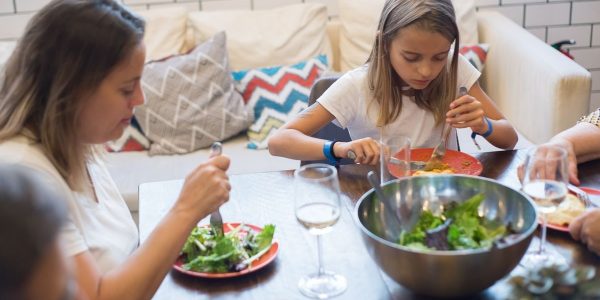 A family enjoying a healthy meal together indoors, emphasizing togetherness and healthy eating.