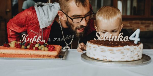 A joyful birthday scene with a father and child. Cakes adorned with decorations and age markers.